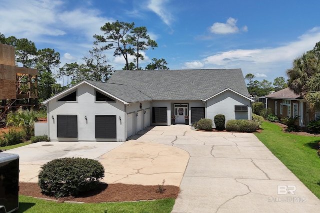 8585 Bay Harbor Rd, Elberta, AL 36530 - view of front facade with stucco siding, roof with shingles, driveway, a garage, and a front lawn