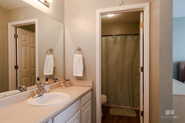 full bathroom featuring toilet, wood finished floors, and vanity