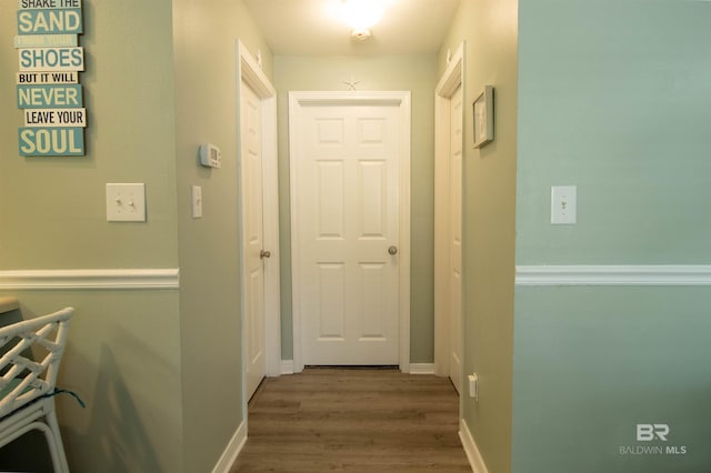 hall featuring baseboards and wood finished floors