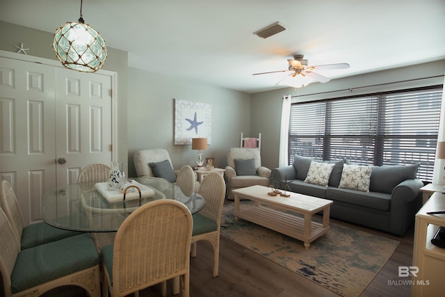 living area featuring dark wood finished floors, visible vents, and a ceiling fan