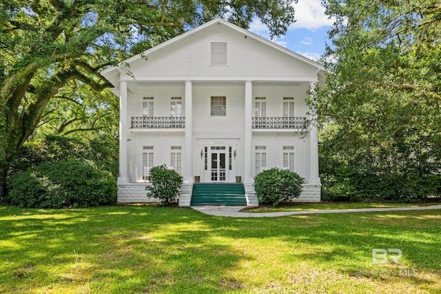 back of house featuring a yard and a balcony