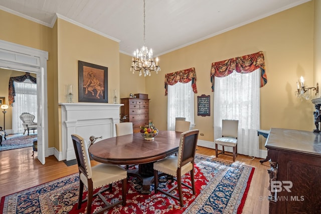 dining room with light hardwood / wood-style flooring, a notable chandelier, a healthy amount of sunlight, and crown molding