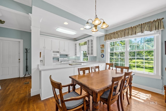 dining area featuring dark hardwood / wood-style floors, crown molding, and an inviting chandelier