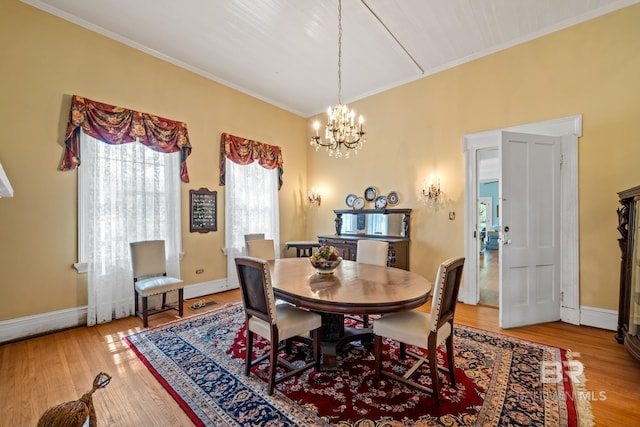 dining space featuring crown molding, a notable chandelier, and hardwood / wood-style flooring