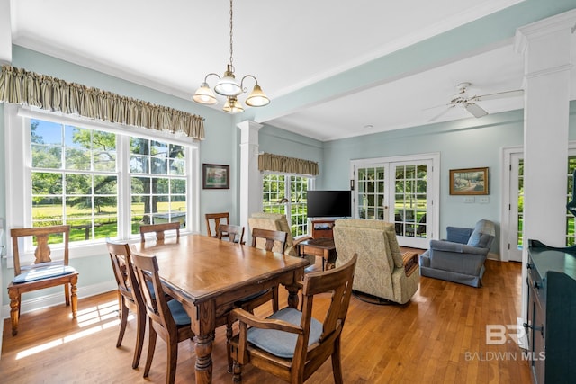 dining area with french doors, ceiling fan with notable chandelier, light hardwood / wood-style floors, and ornate columns