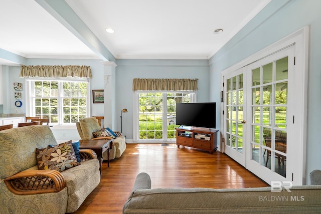 living room with french doors, hardwood / wood-style flooring, and crown molding