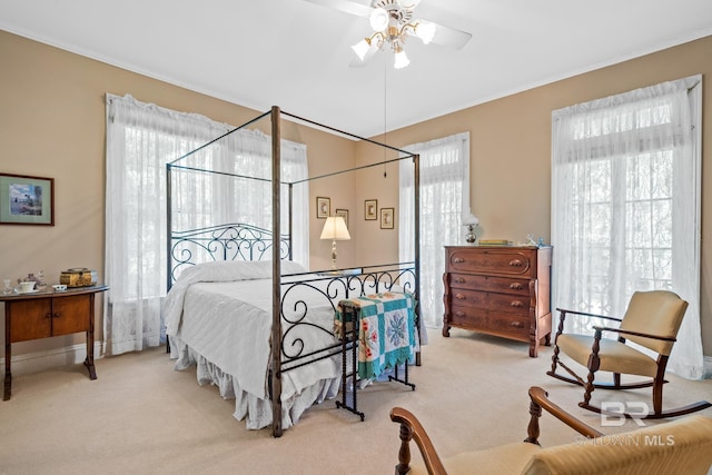 carpeted bedroom with ceiling fan and crown molding