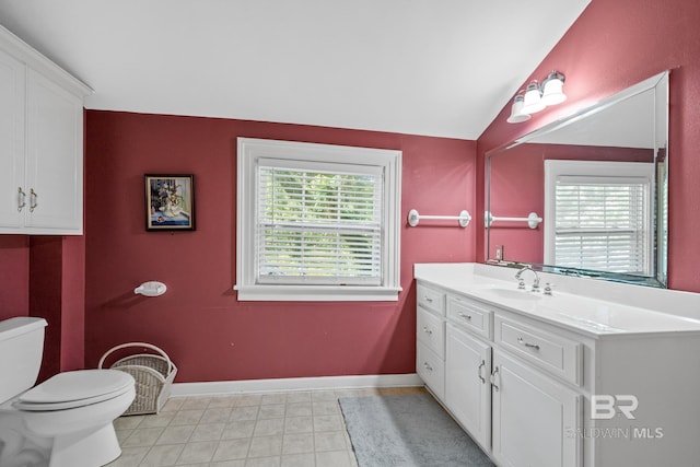 bathroom with toilet, vanity, vaulted ceiling, and a wealth of natural light