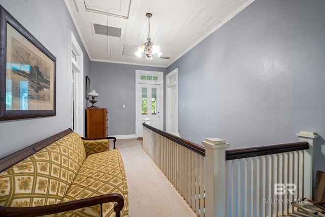 corridor featuring a notable chandelier, crown molding, and light carpet