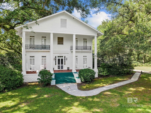 neoclassical / greek revival house featuring a balcony and a front yard