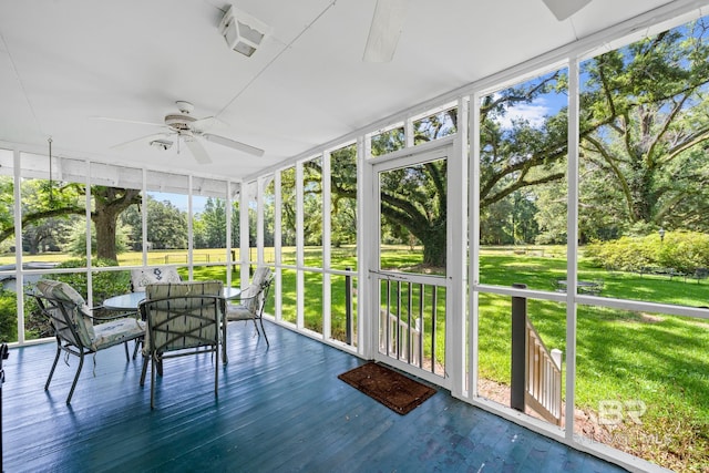 unfurnished sunroom with ceiling fan