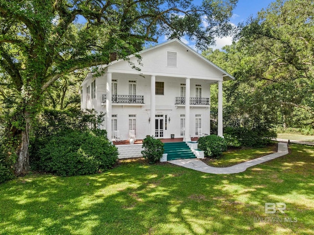 greek revival house with a balcony and a front yard