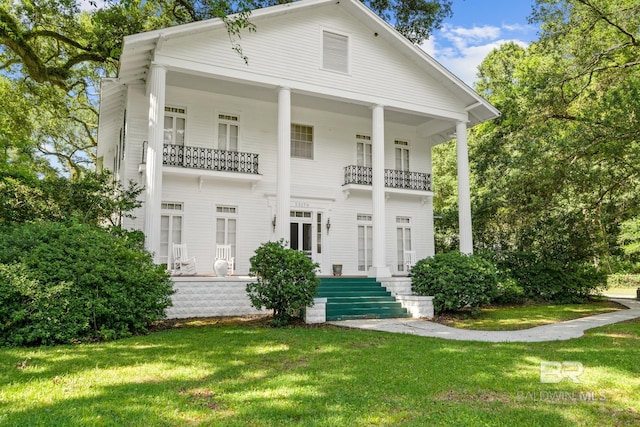 view of front of property with a balcony and a front lawn