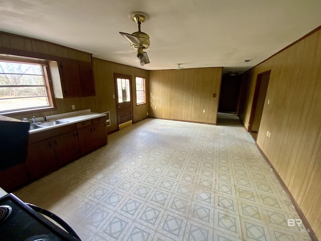 kitchen with sink, ceiling fan, and wooden walls