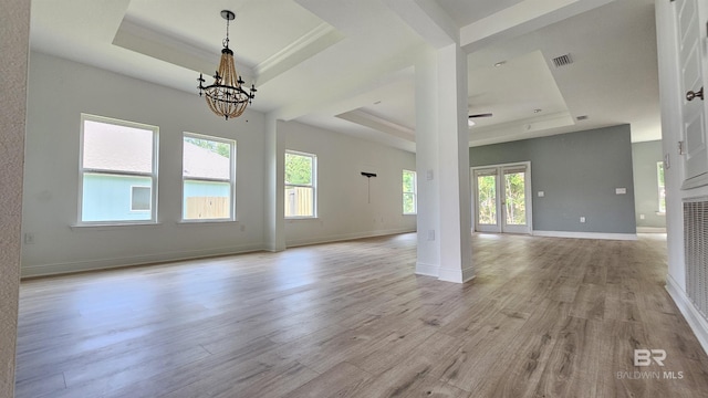 1897 Carly St, Foley, AL 36535 - unfurnished living room featuring a tray ceiling, a chandelier, light wood-style floors, baseboards, and crown molding