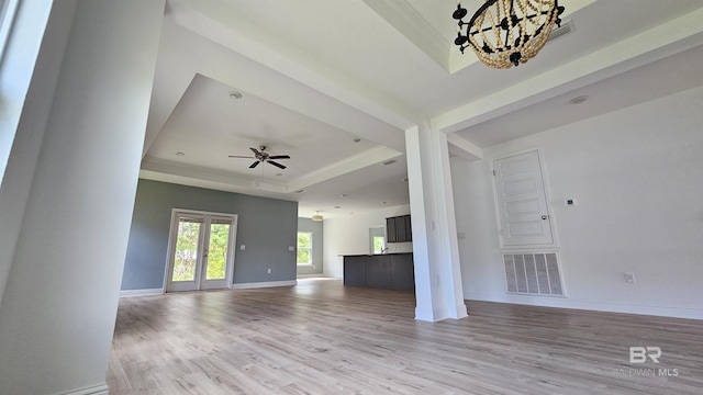 1897 Carly St, Foley, AL 36535 - unfurnished living room with a tray ceiling, light wood-style floors, a chandelier, baseboards, and ceiling fan