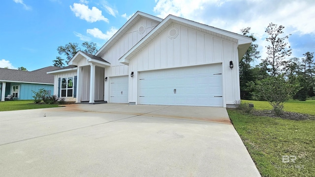 1897 Carly St, Foley, AL 36535 - view of front of home featuring board and batten siding, concrete driveway, an attached garage, and a front yard