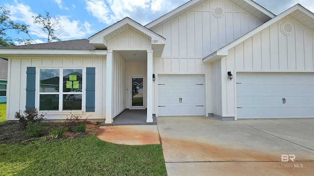 1897 Carly St, Foley, AL 36535 - view of front of home with board and batten siding, driveway, an attached garage, and roof with shingles
