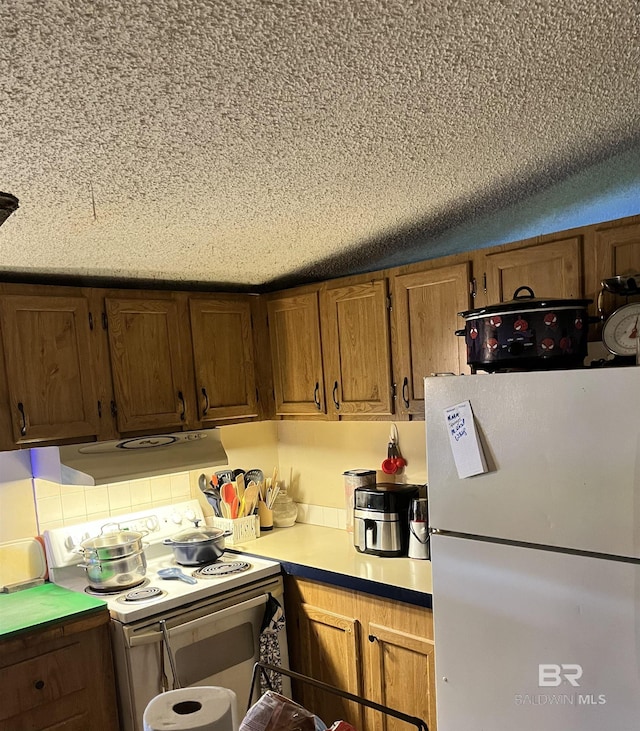 158 N Wren Ln, Robertsdale, AL 36567 - kitchen with white appliances, extractor fan, light countertops, brown cabinetry, and a textured ceiling