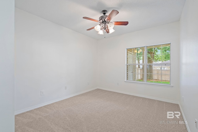 carpeted spare room with ceiling fan