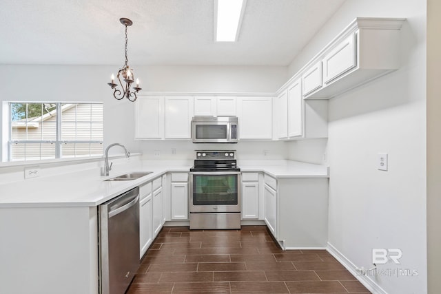 kitchen featuring dark hardwood / wood-style flooring, sink, white cabinetry, appliances with stainless steel finishes, and decorative light fixtures