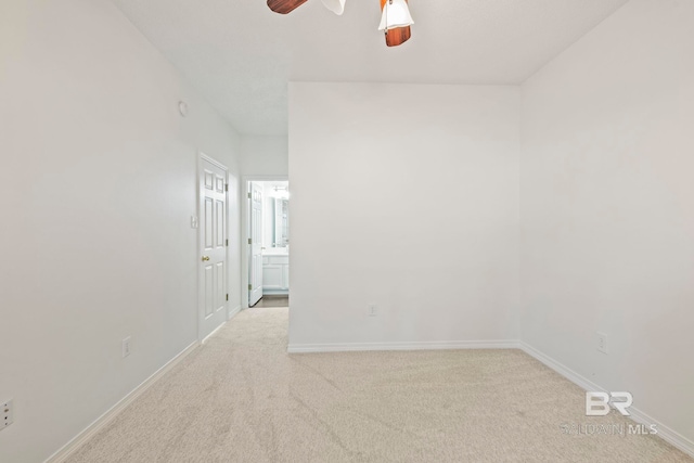 spare room with light colored carpet and ceiling fan