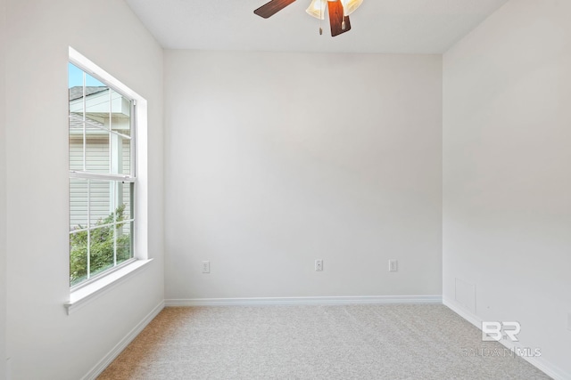 unfurnished room with light colored carpet, ceiling fan, and plenty of natural light