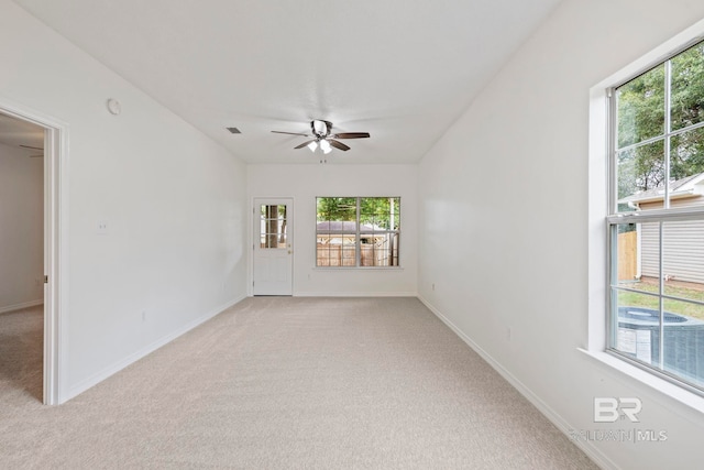 carpeted empty room featuring ceiling fan and a healthy amount of sunlight