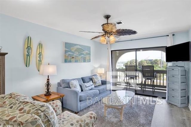 living room featuring a ceiling fan and wood finished floors