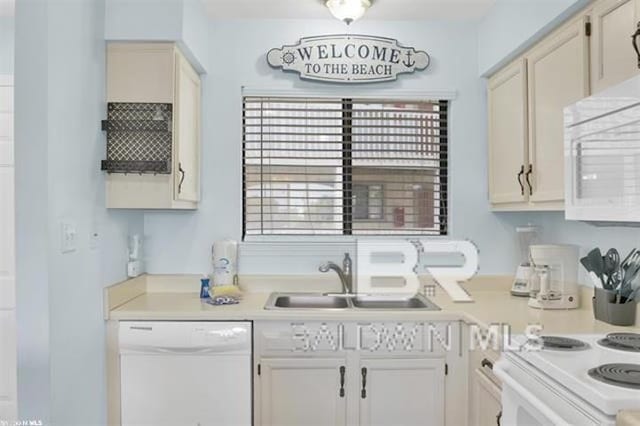 kitchen featuring light countertops, white appliances, and a sink