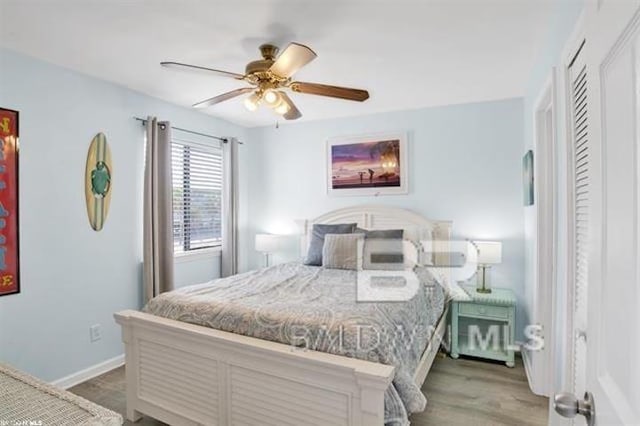 bedroom featuring a ceiling fan, baseboards, and wood finished floors