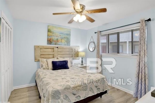 bedroom featuring ceiling fan, a closet, baseboards, and wood finished floors