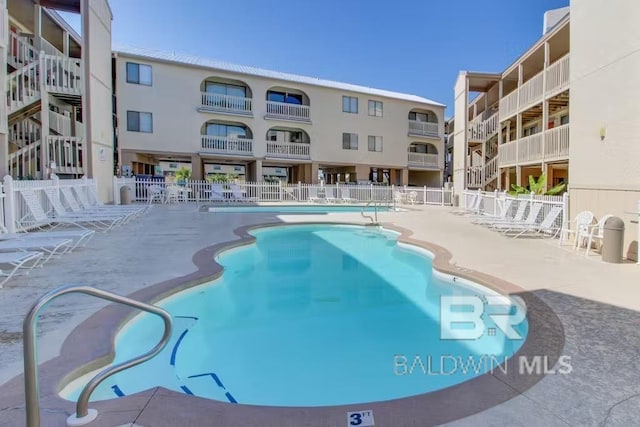 community pool featuring a patio area and fence