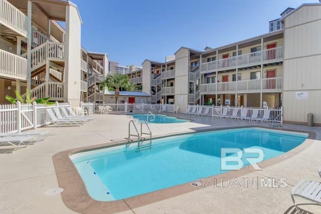 pool featuring fence and a patio