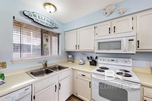 kitchen with white cabinets, white appliances, light countertops, and a sink