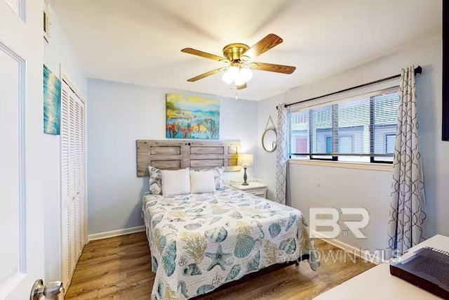 bedroom featuring ceiling fan, a closet, baseboards, and wood finished floors