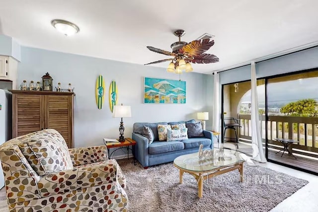 living area with ceiling fan and expansive windows