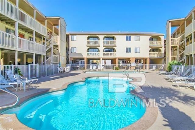 pool with fence and a patio