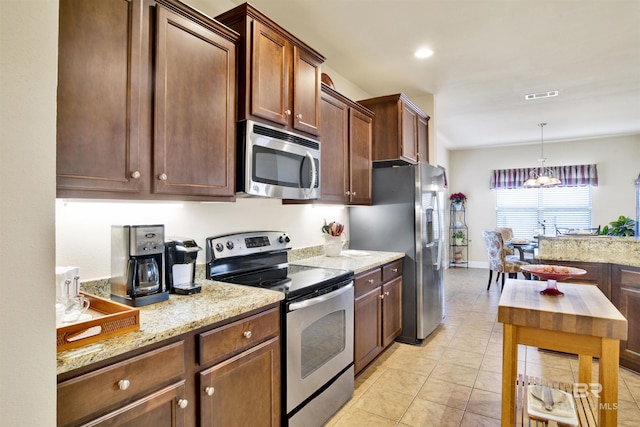 7091 Rocky Road Loop, Gulf Shores, AL 36542 - kitchen with light stone counters, hanging light fixtures, visible vents, light tile patterned flooring, and appliances with stainless steel finishes