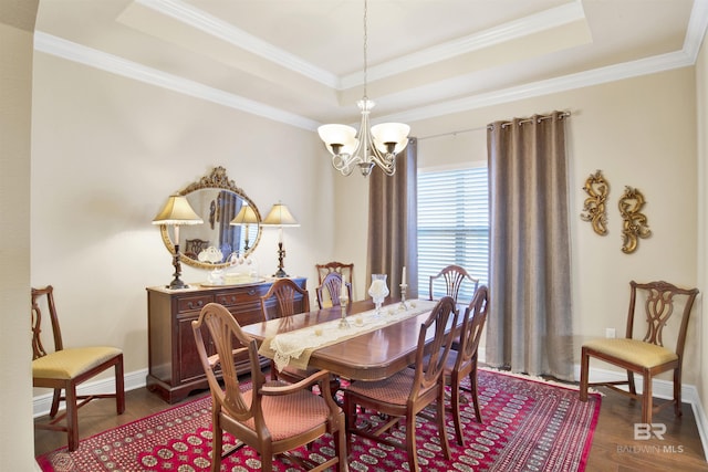 7091 Rocky Road Loop, Gulf Shores, AL 36542 - dining space featuring an inviting chandelier, dark wood-style flooring, a raised ceiling, and crown molding