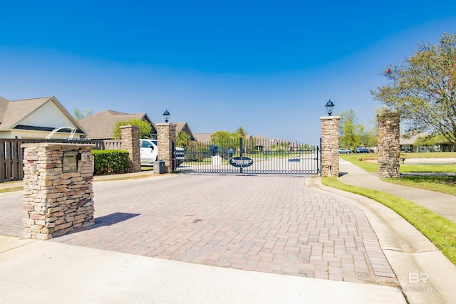 7091 Rocky Road Loop, Gulf Shores, AL 36542 - view of community featuring decorative driveway, fence, and a gate