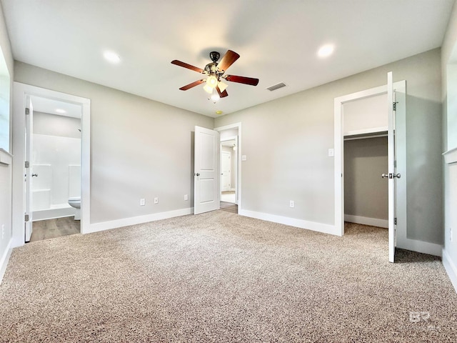 unfurnished bedroom with visible vents, a spacious closet, carpet, and baseboards