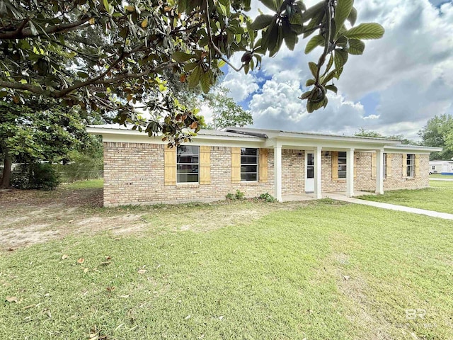 ranch-style house featuring brick siding and a front lawn