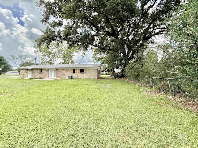 view of yard with fence and central AC