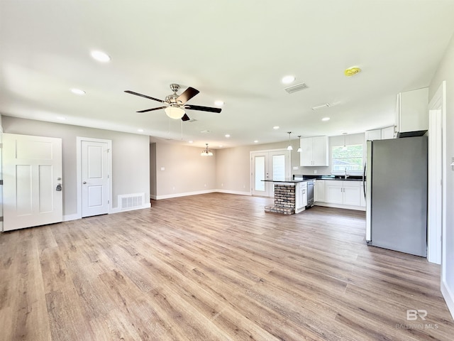 unfurnished living room with visible vents, recessed lighting, and light wood-type flooring