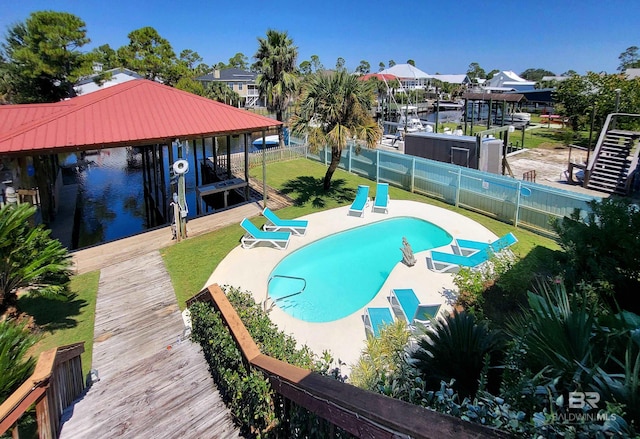 view of swimming pool with a water view and a boat dock