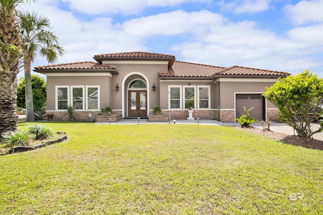 mediterranean / spanish-style home with french doors, a garage, a front lawn, stone siding, and stucco siding