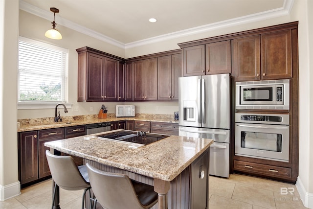 kitchen featuring light tile patterned flooring, light stone countertops, a kitchen bar, a center island, and appliances with stainless steel finishes