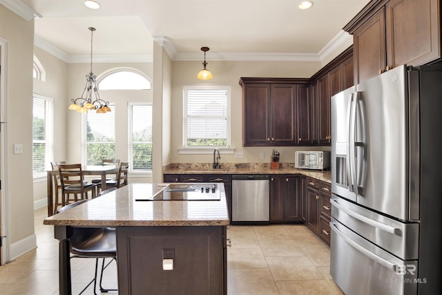 kitchen featuring light tile patterned floors, plenty of natural light, a kitchen island, and stainless steel appliances