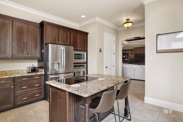 kitchen featuring a kitchen breakfast bar, arched walkways, light tile patterned floors, ornamental molding, and stainless steel appliances